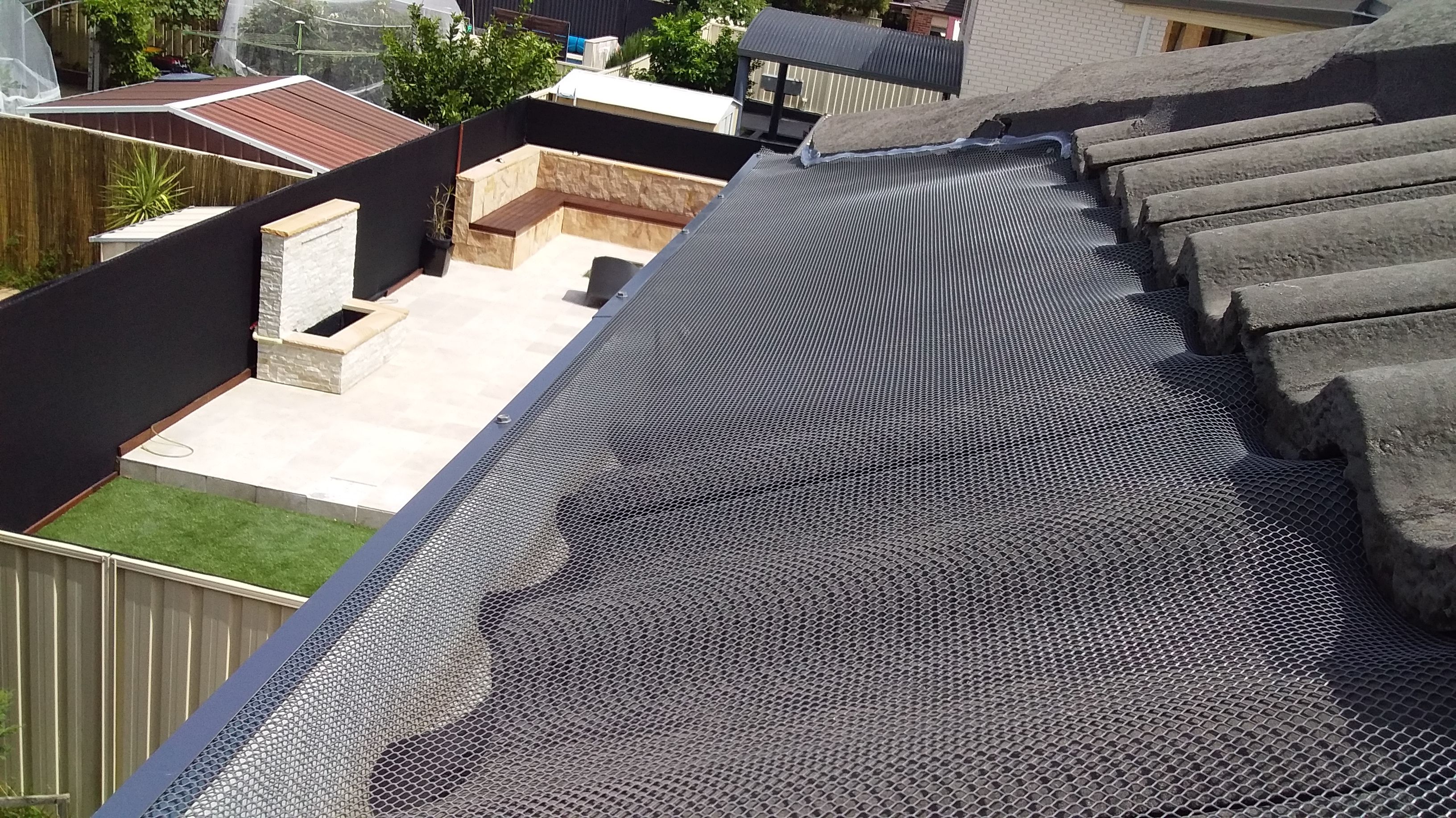 Gutter guard install on corrugated roof beside solar panels