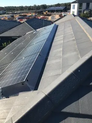 Solar panel perimeter bird-proofing mesh on charcoal tiled roof