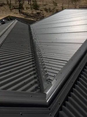 Drone view charcoal metal roof with solar panels after gutter protection